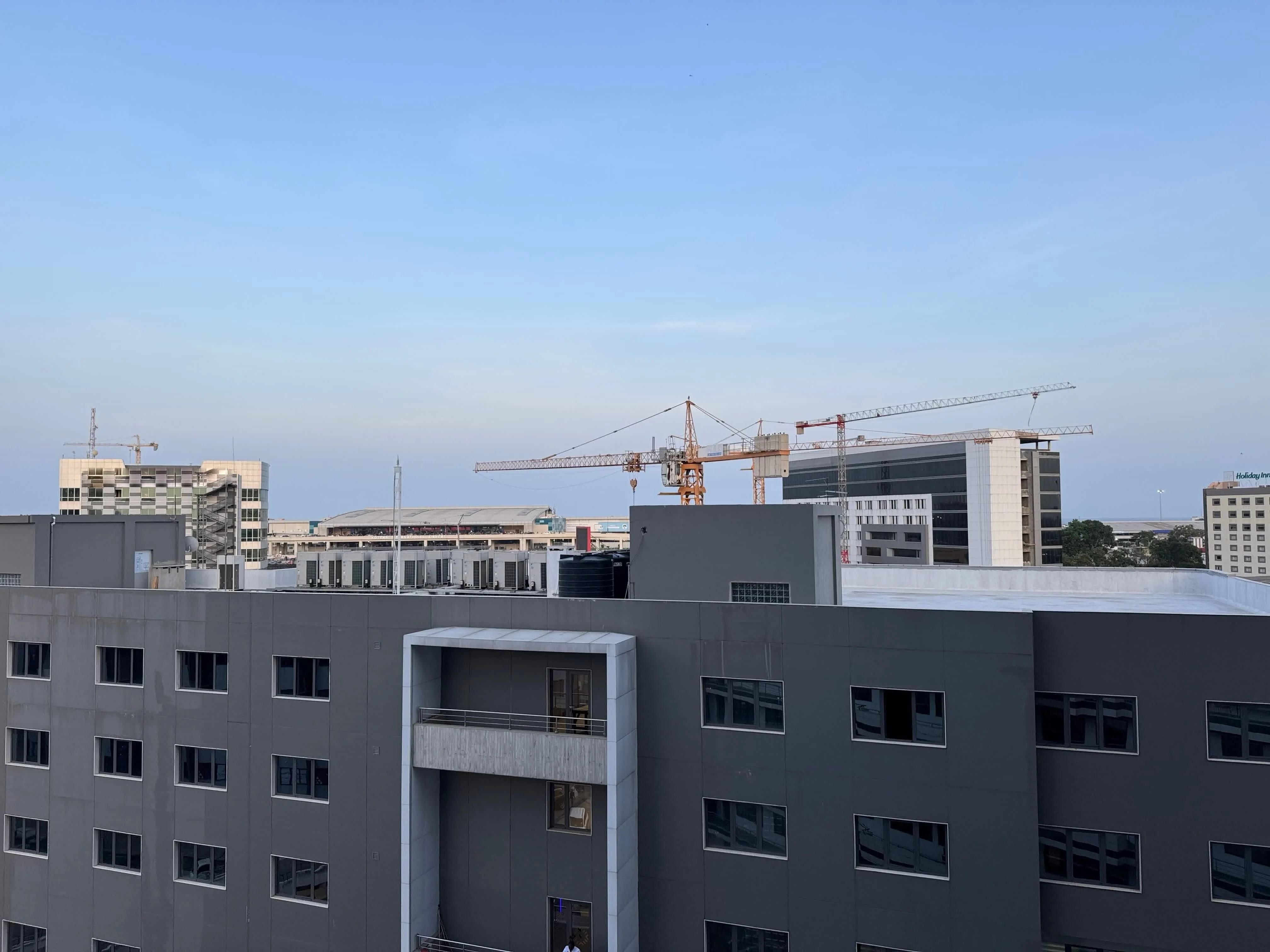 Modern building under construction with cranes on the African skyline