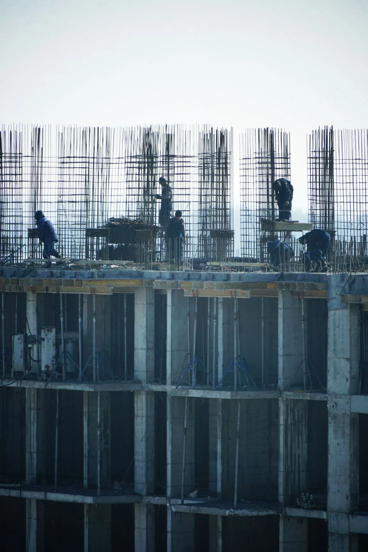 Construction workers on rebar formwork at a high-rise building site