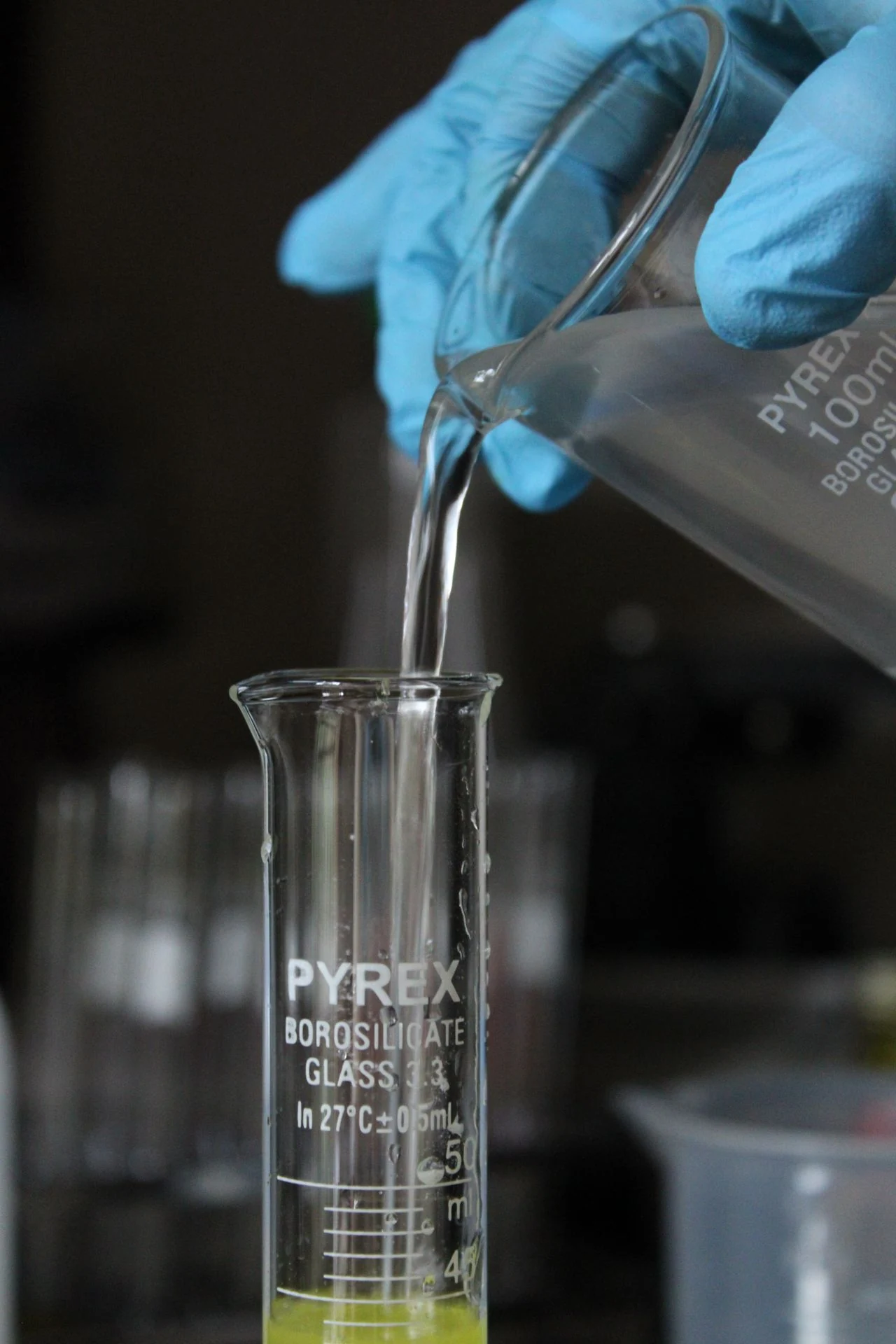 Water sample being poured into a graduated cylinder for treatment testing
